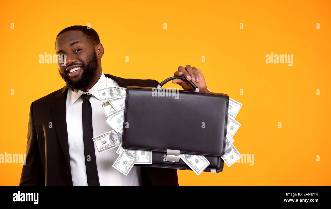 Fröhliche african-american man Holding Handtasche mit Dollar cash und lächelnd Stockfoto