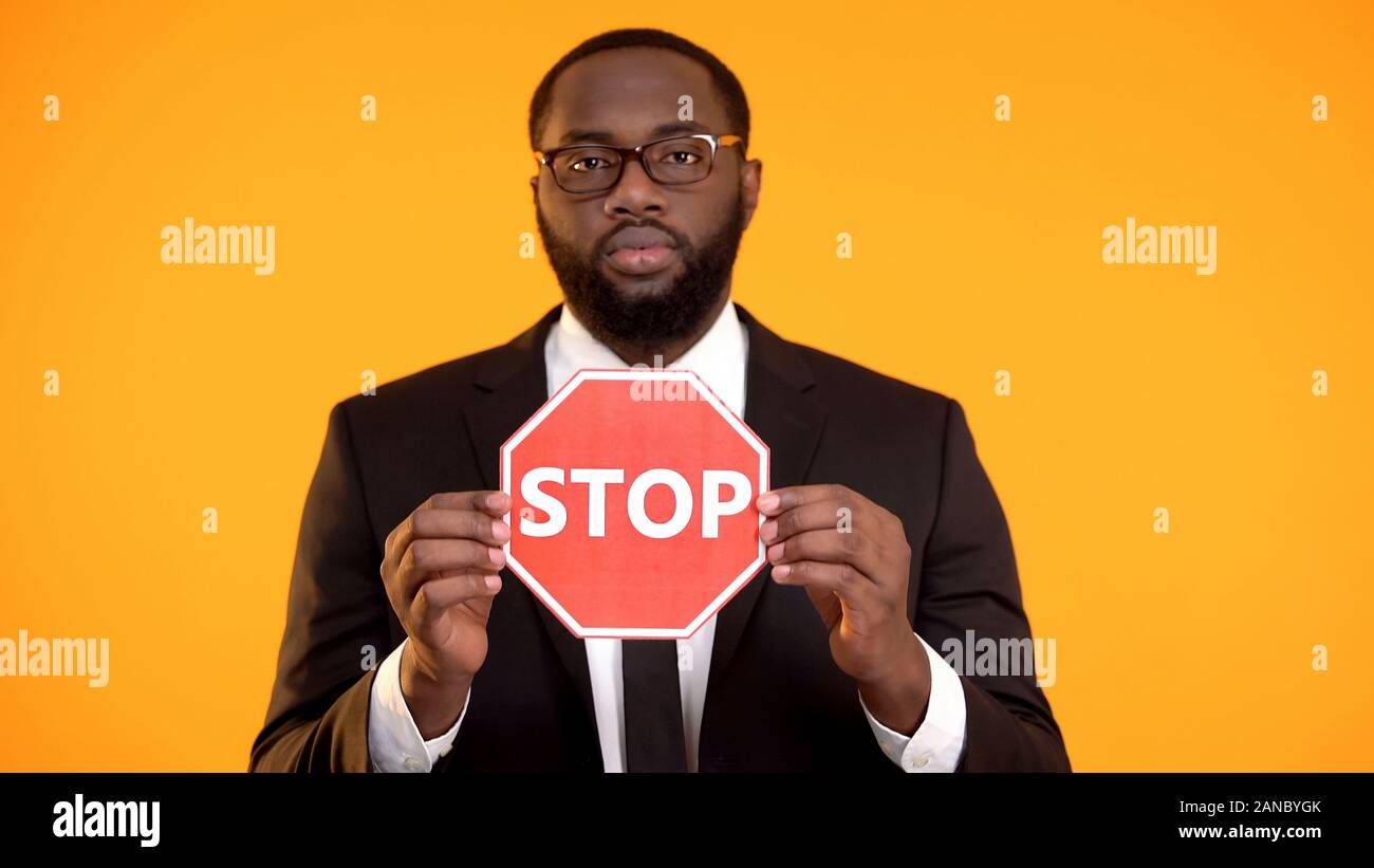 Schwarzer Mann in Anzug, STOP-Schild, antirassismus Kampagne, soziale Gleichheit Stockfoto
