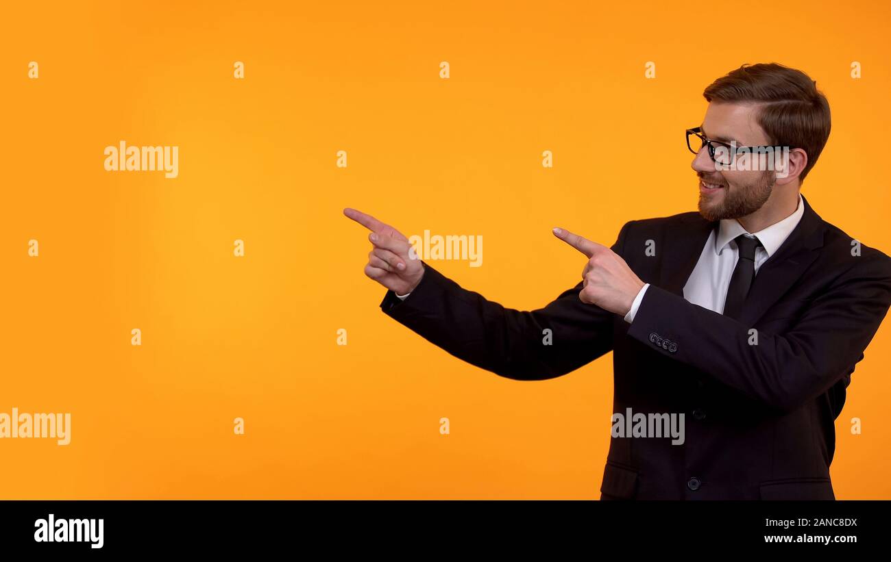 Glücklicher Mann in Anzug, der auf gelbem Hintergrund, Platz für Ihren Text, Vorlage Stockfoto