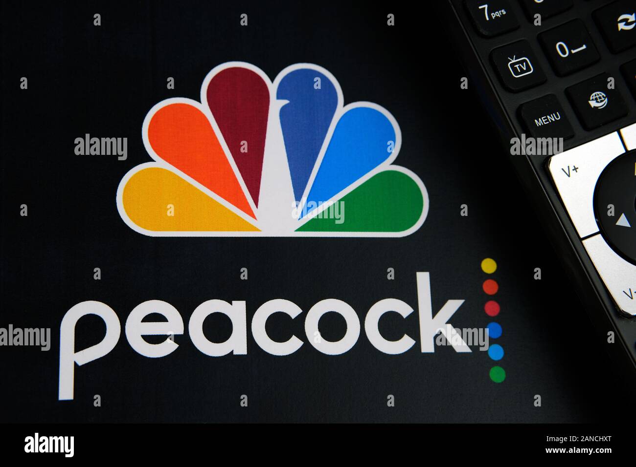Peacock Video Streaming Service Logo auf dem Papier Broschüre und die Fernbedienung. Durch NBCUniversal, eine Tochtergesellschaft von Comcast. Stockfoto