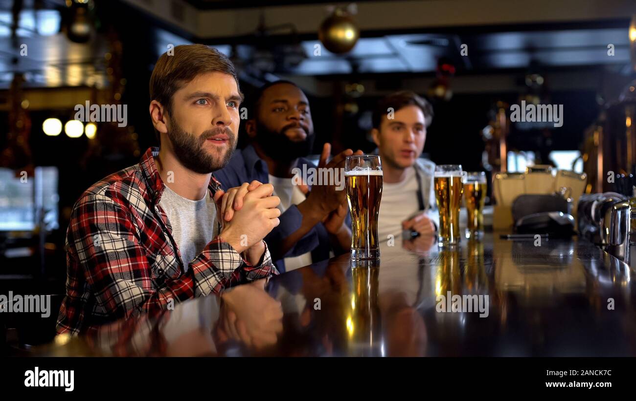 In dem Bestreben, multirassischen Freunde jubeln für den Sport Spiel im Pub, Wildbeobachtung auf dem Fernseher Stockfoto