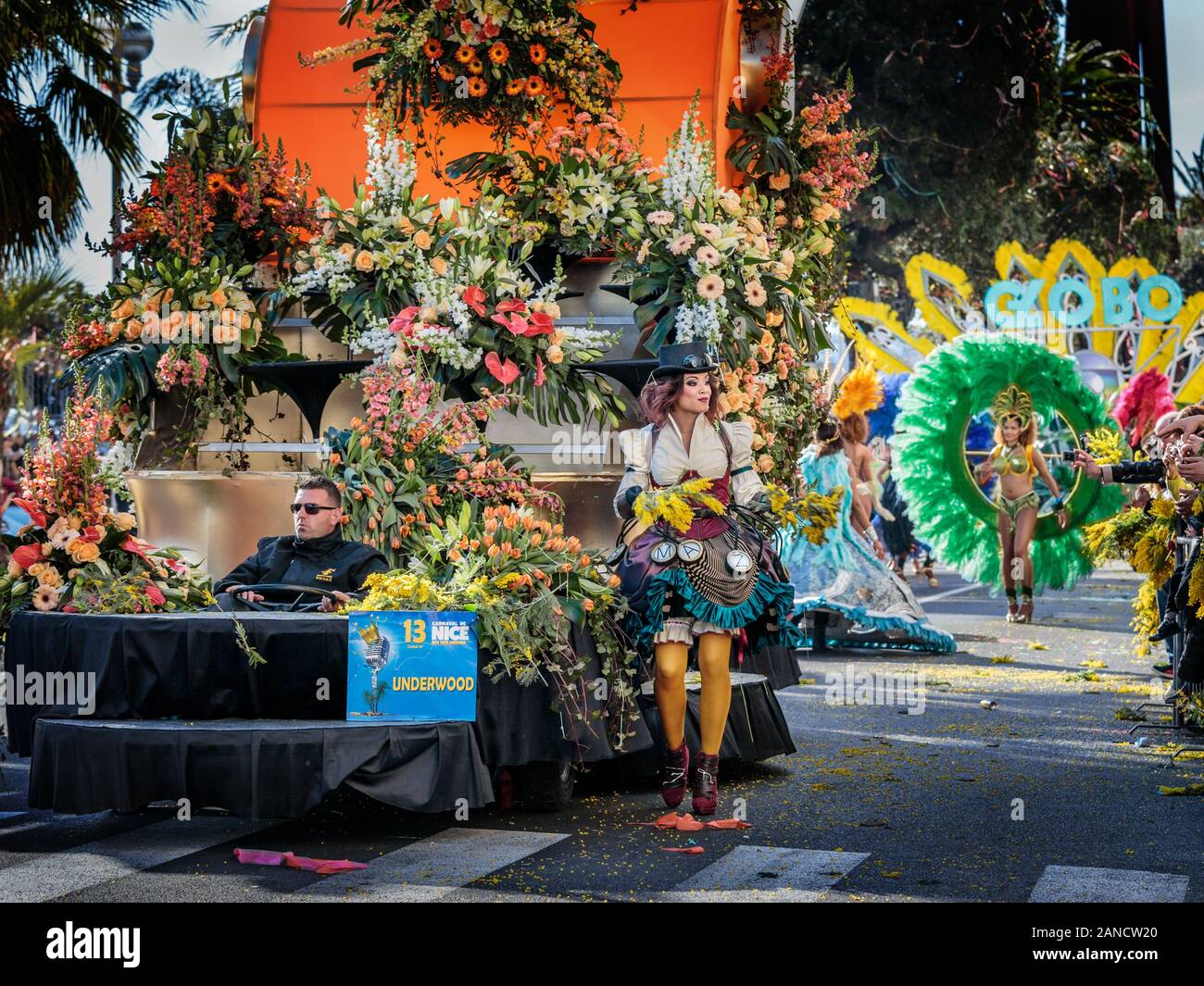 Mädchen werfen Blumen von Schwielen auf die Blumenparade, den Karneval von Nizza, die französische Riviera, Cote d'Azur, Frankreich. Stockfoto