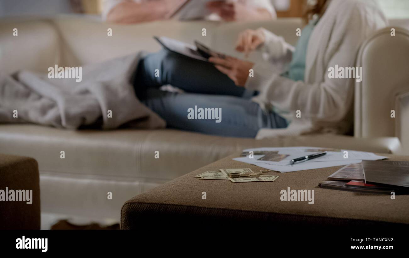 Dollar auf dem Tisch liegende Frau auf der Couch und zählen Aufwendungen, Planung Budget Stockfoto