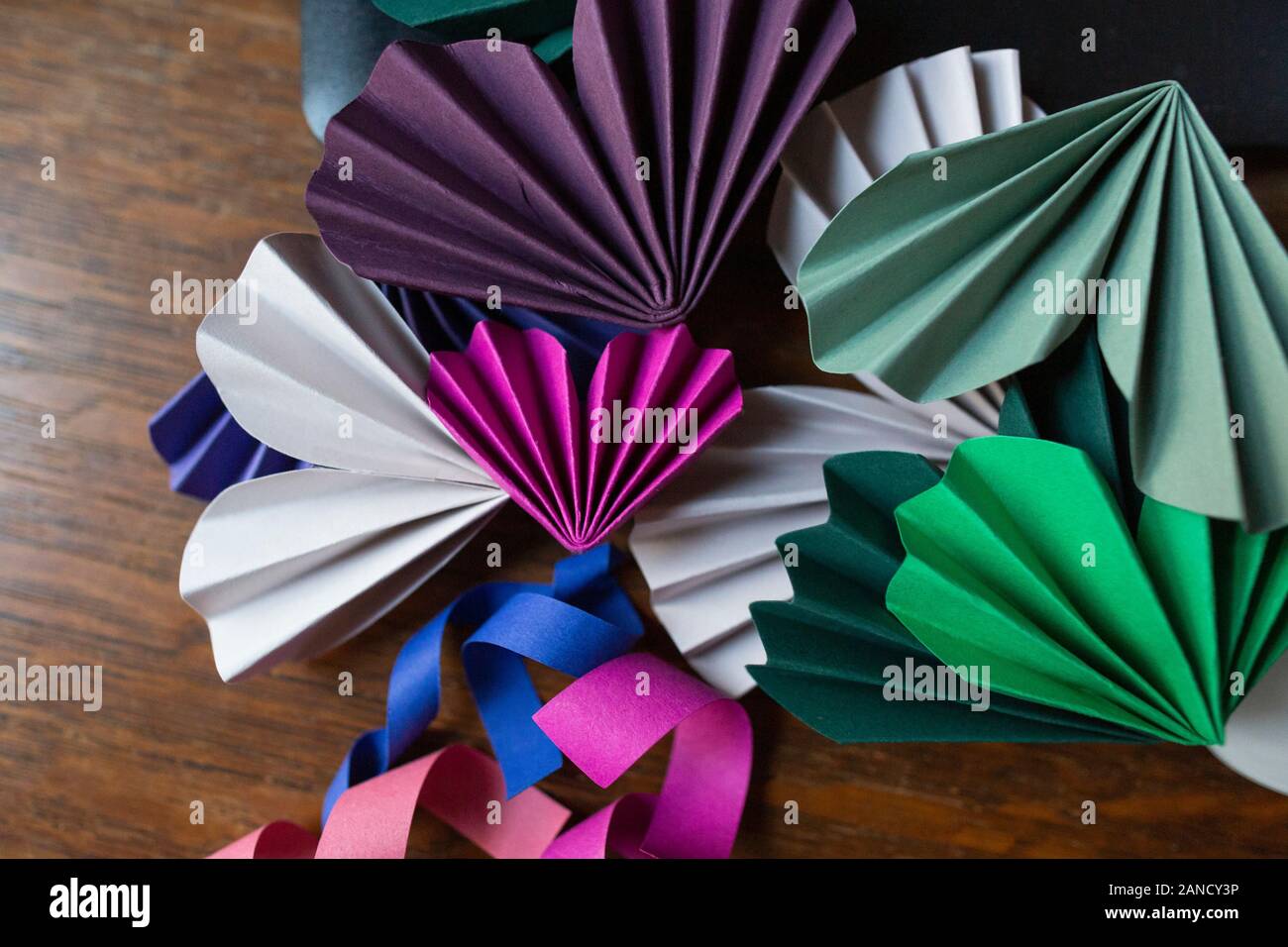Papierhandwerk in verschiedenen Farben auf Holzfläche gestapelt Stockfoto