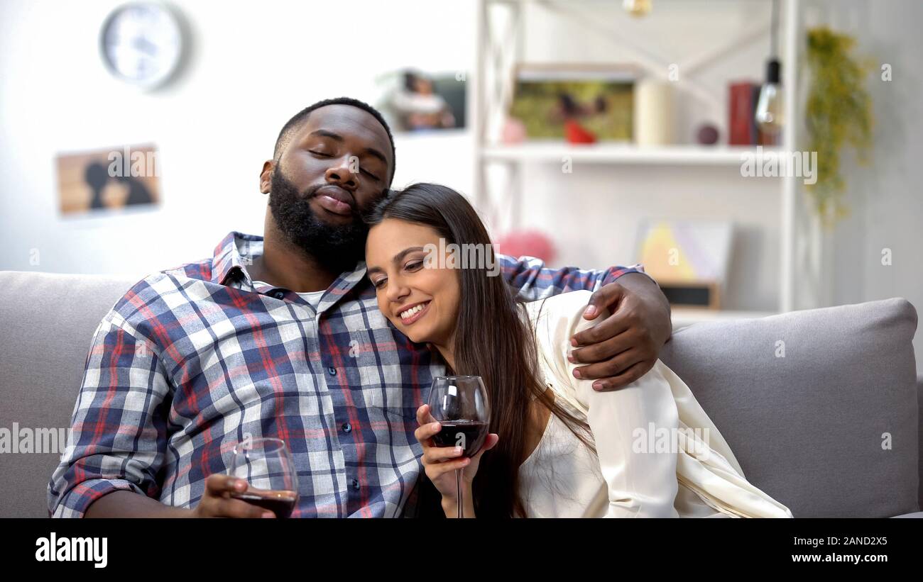 Sweet mixed-Race Paar umarmen und Entspannen mit Wein zu Hause, in der Freizeit Stockfoto