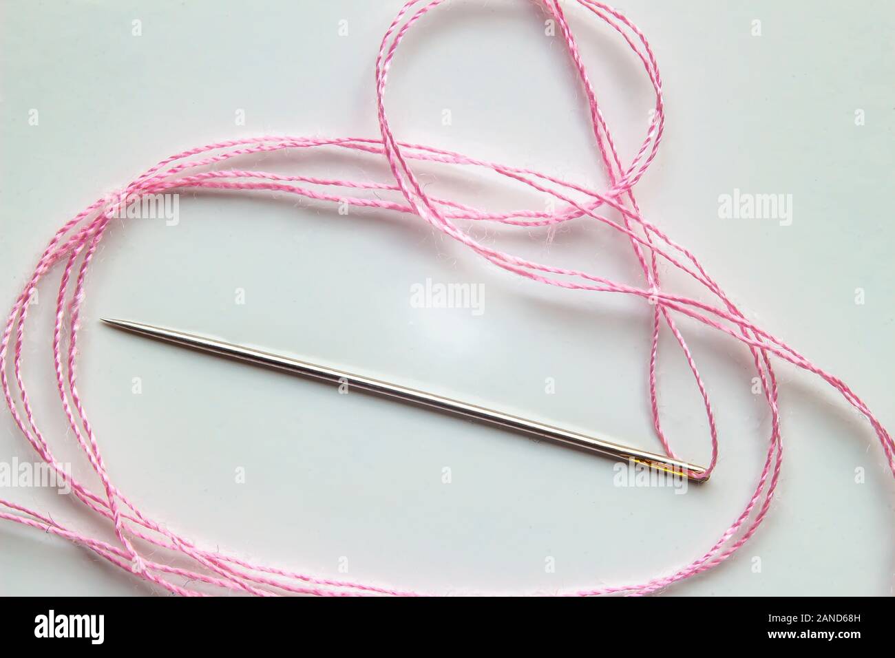 Nadel mit einem Rosa auf weißem Hintergrund Stockfoto
