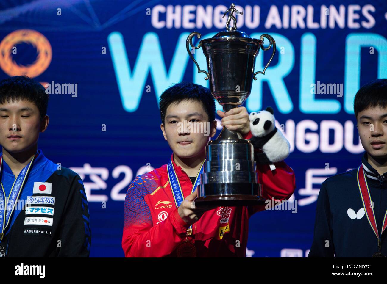 Ventilator Zhendong von China zeigt die Medaille und Pokal, nachdem er den ersten Platz beim Finale der International Table Tennis Federation (ITTF) Men's World C Stockfoto