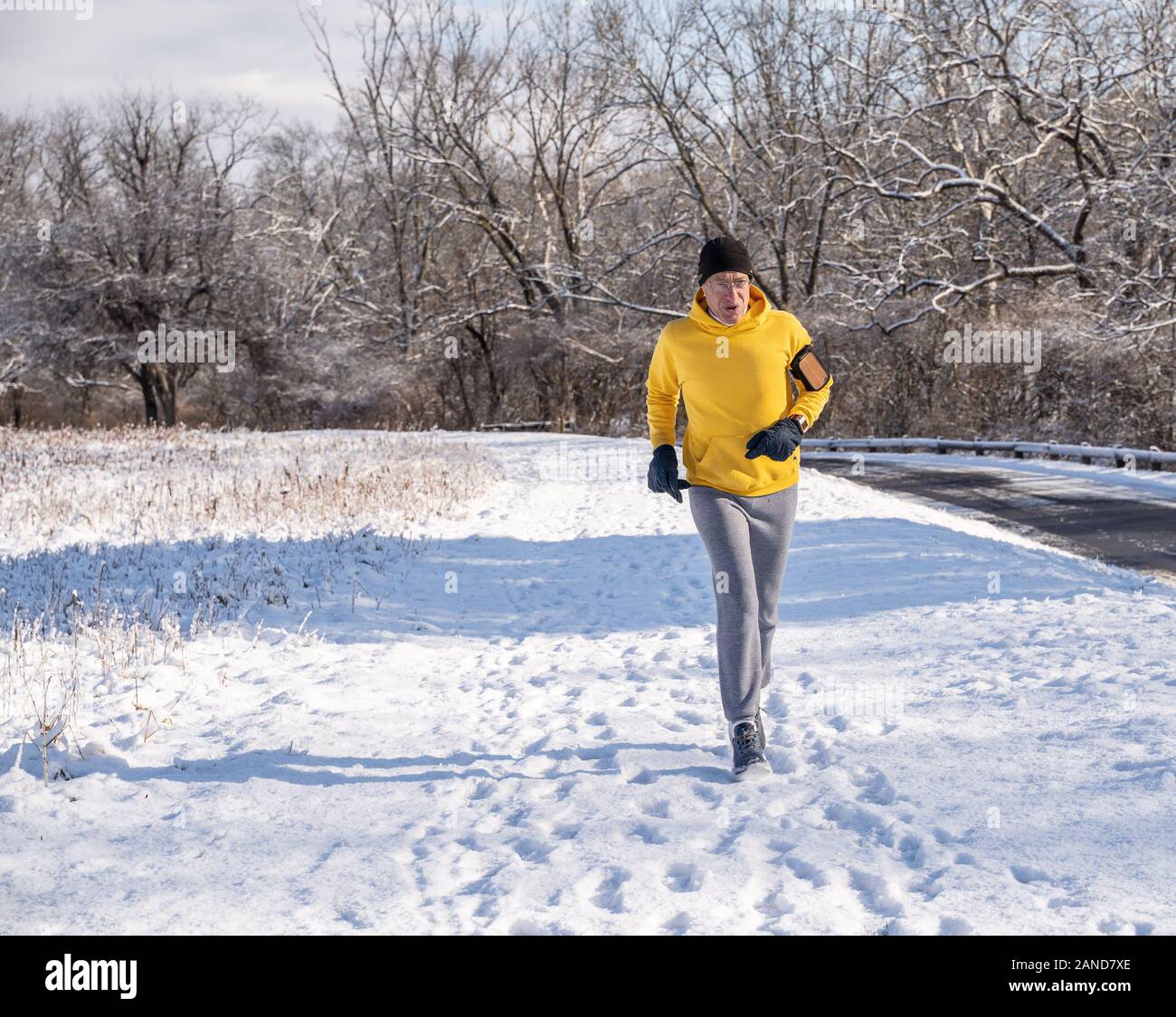 Berks County, Pennsylvania, 8. Januar 2020: älterer Mann laufen auf verschneiten Pfad Stockfoto