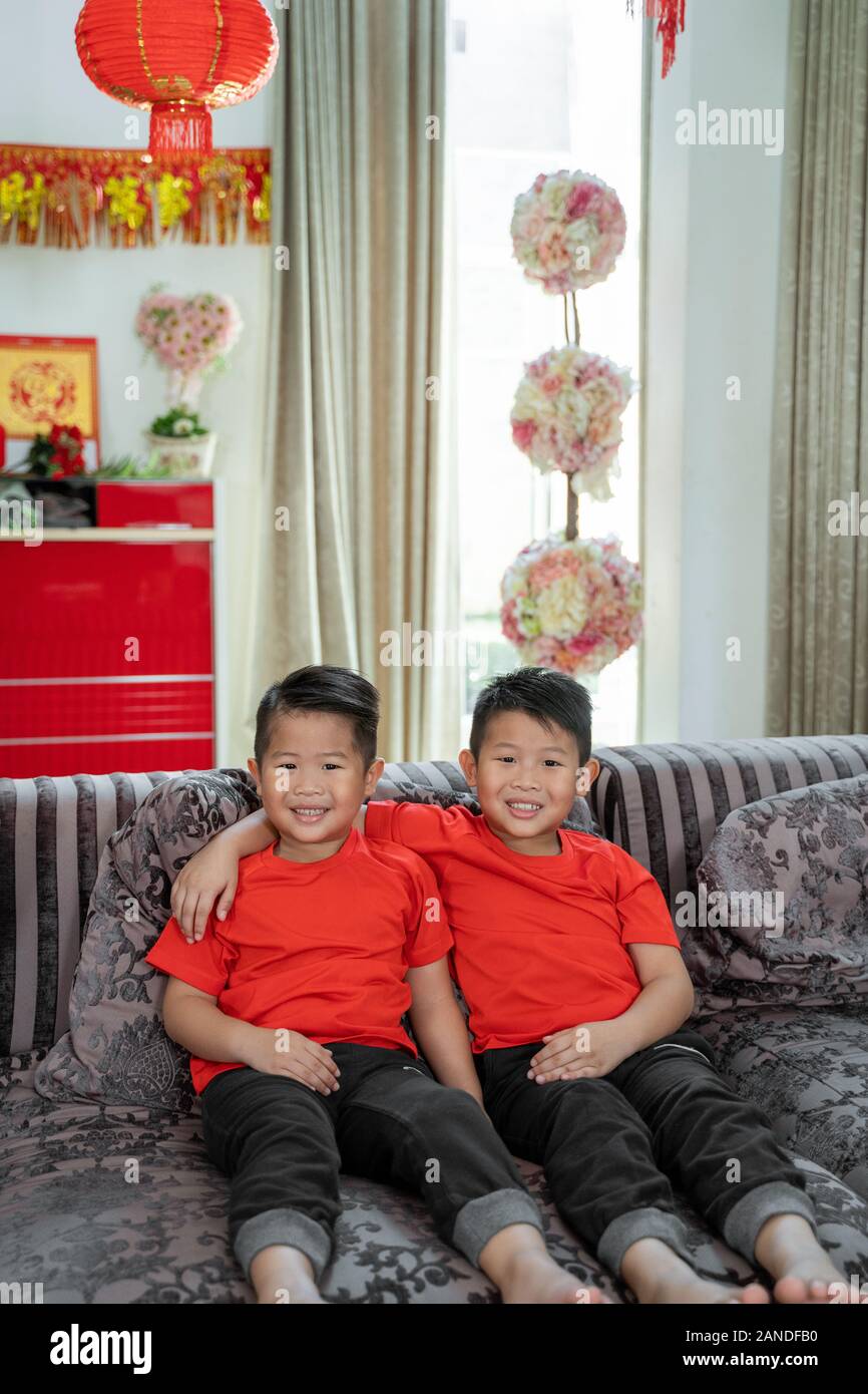 Zwei asiatische chinesische Jungen Lächeln tragen rote T-Shirts Stockfoto