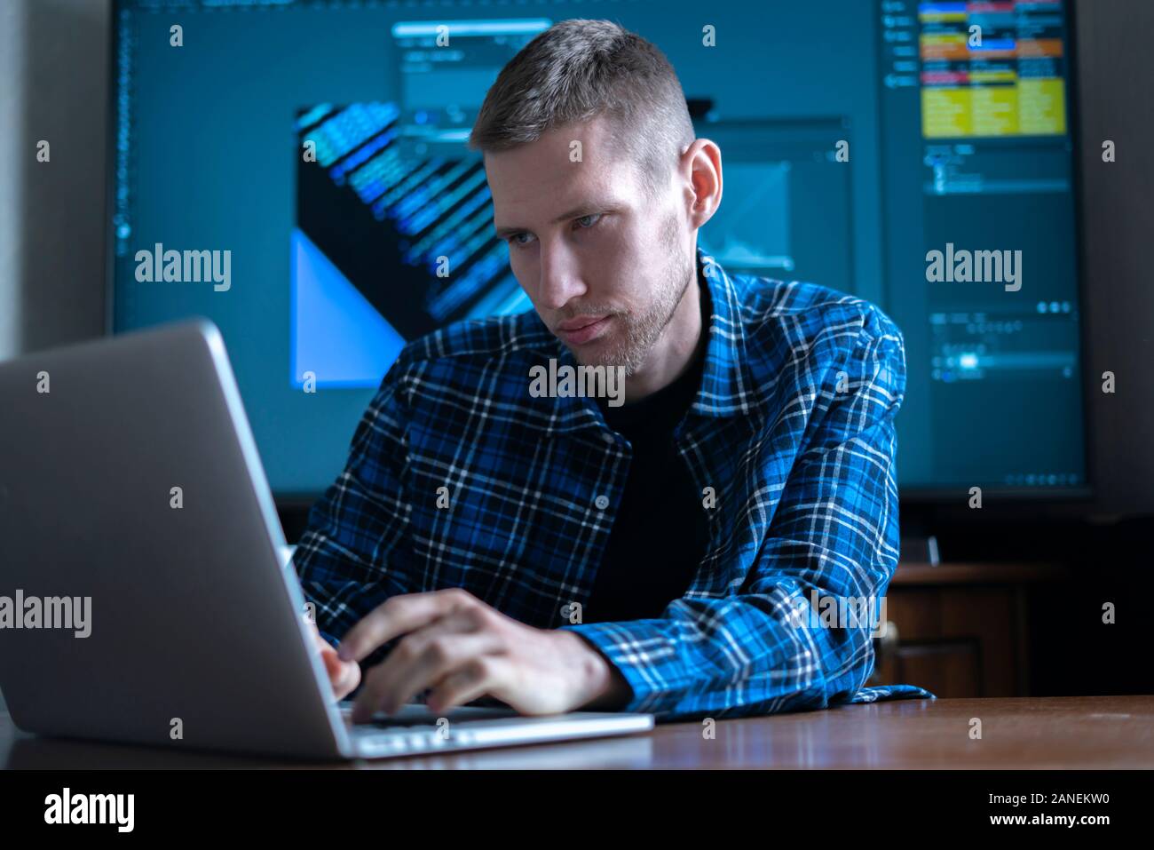 Die männlichen Fotograf am Tisch sitzen, arbeiten am Computer, mit der Software Anwendung Stockfoto