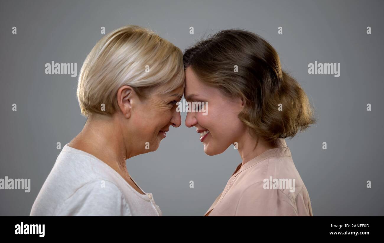 Erwachsene Tochter und Mutter berühren Stirnen suchen, Familie Liebe Stockfoto