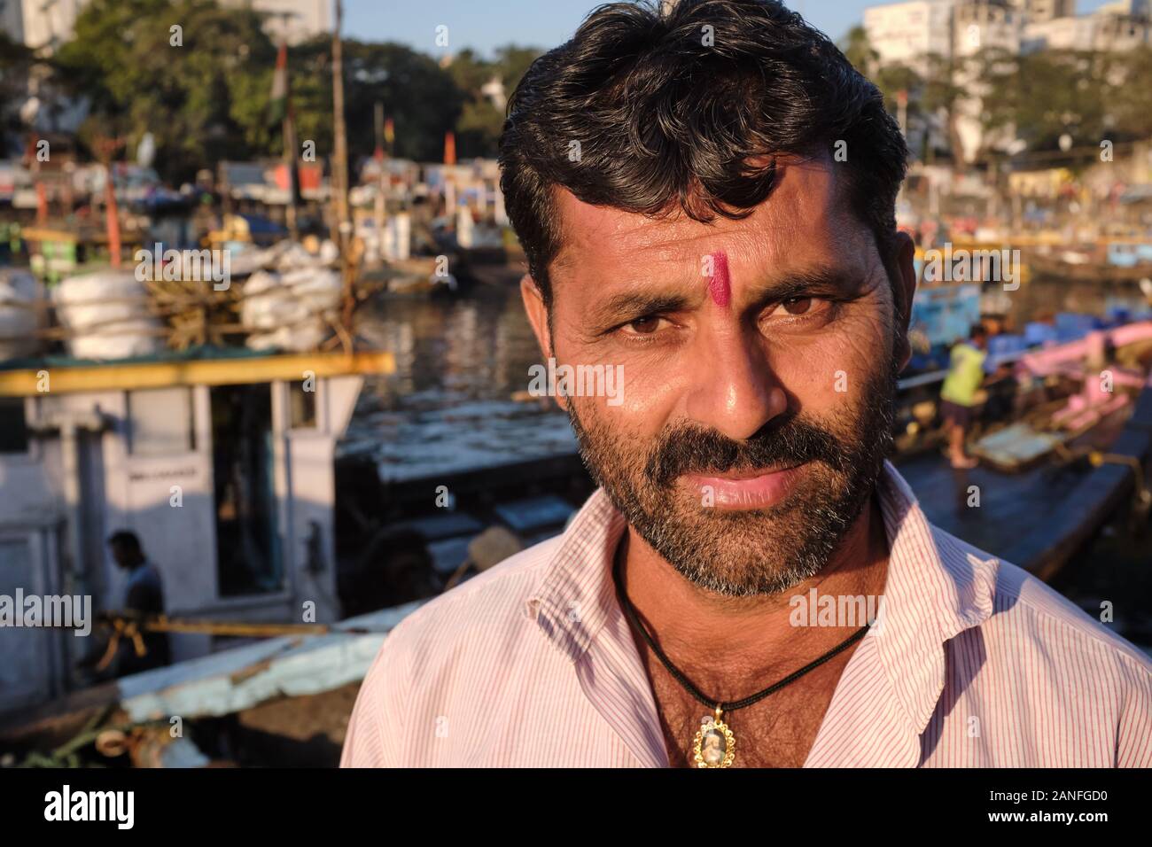 Ein Maharashtrianer Fischer mit roter tika-Markierung und einem Medaillon des maharashtrianischen Volkshelden Shivaji, an den Sassoon Docks, Colaba, Mumbai, Maharashtra, Indien Stockfoto