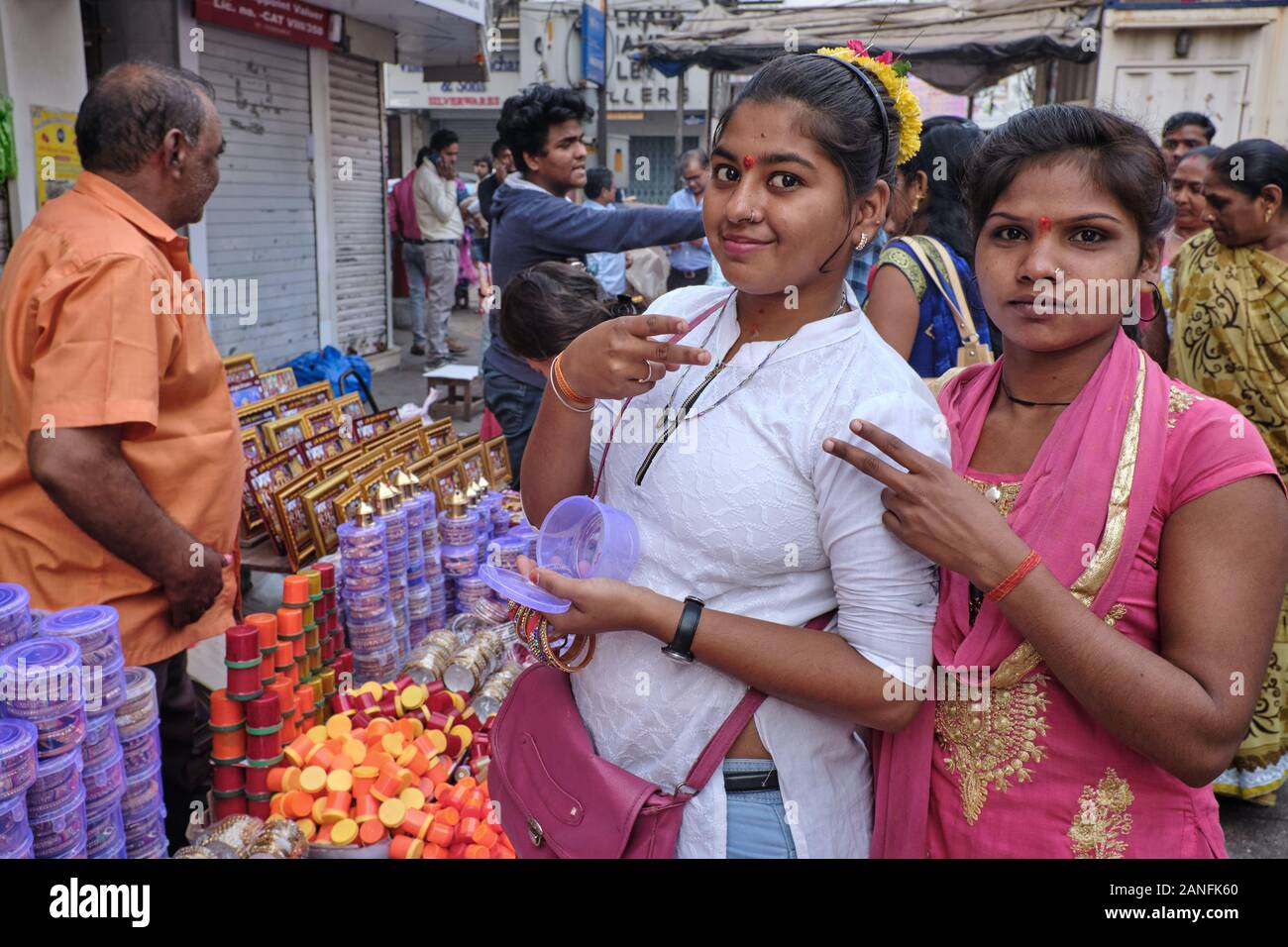 Zwei junge Einkäufer in der Gegend von Zaveri Bazar in Mumbai, Indien, blinken ein coy V-Zeichen Stockfoto