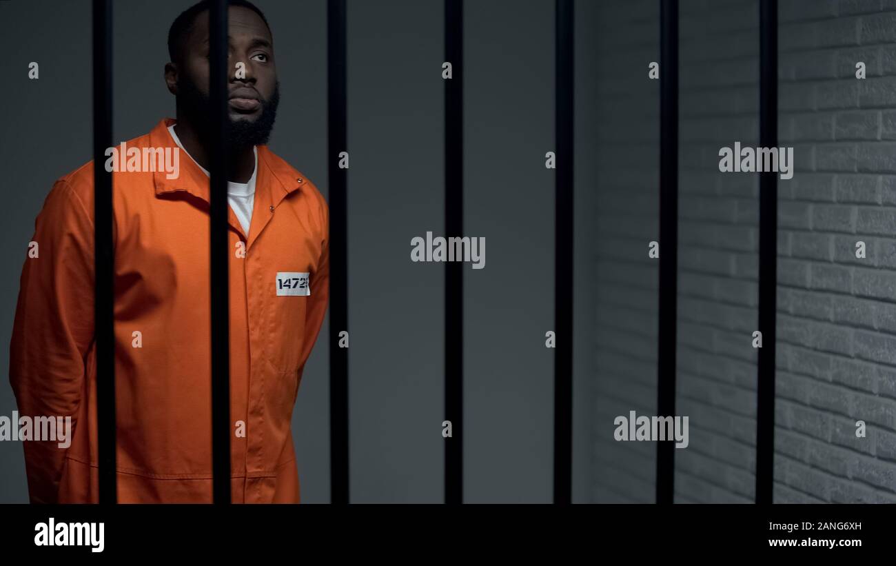 Gleichgültig afro-amerikanische Gefangene beten in Zelle zu Gott, Warten auf Satz Stockfoto