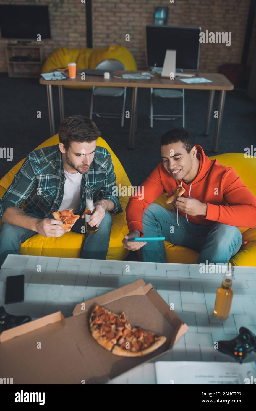 Blick von oben auf die freudige junge Männer essen Pizza Stockfoto