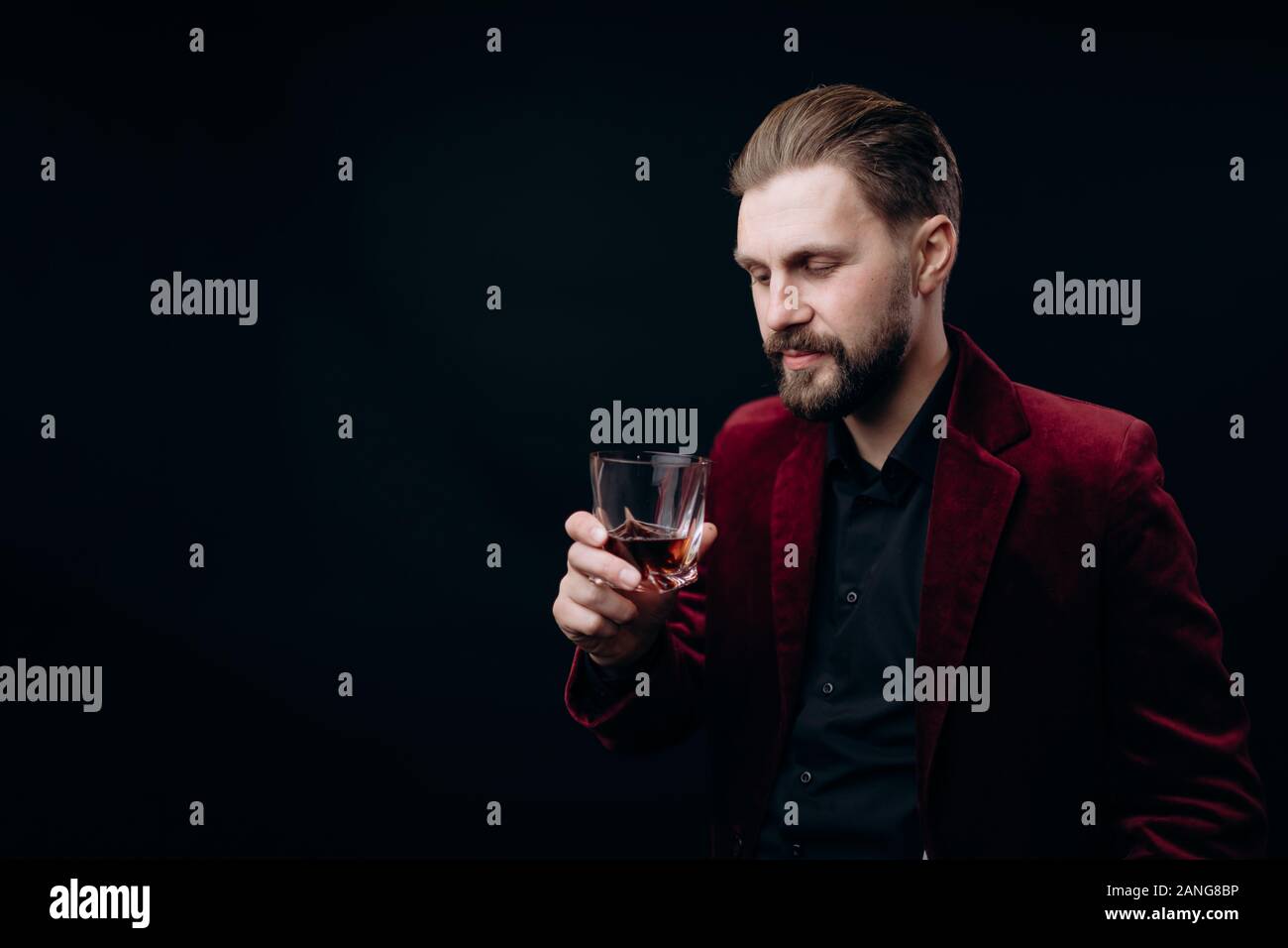 Stilvolle Mann in Velvet Jacket auf sein Getränk Stockfoto