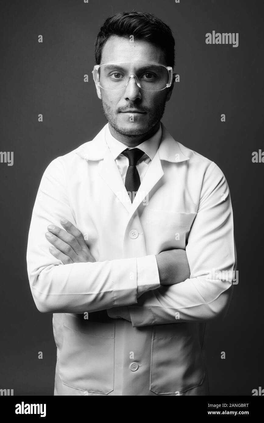 Junge schöne Hispanic Mann Arzt tragen Schutzbrille Stockfoto