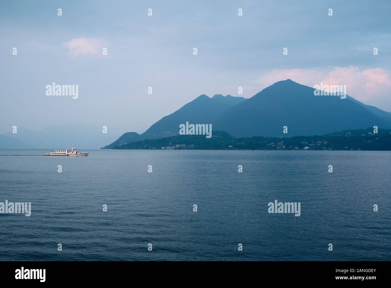 Eine touristische Passagier Fähre Kreuzfahrten Wasser und Berg Horizont des Lago Maggiore in der Dämmerung in der Italienischen Seen, Piemont, Italien EU. Stockfoto