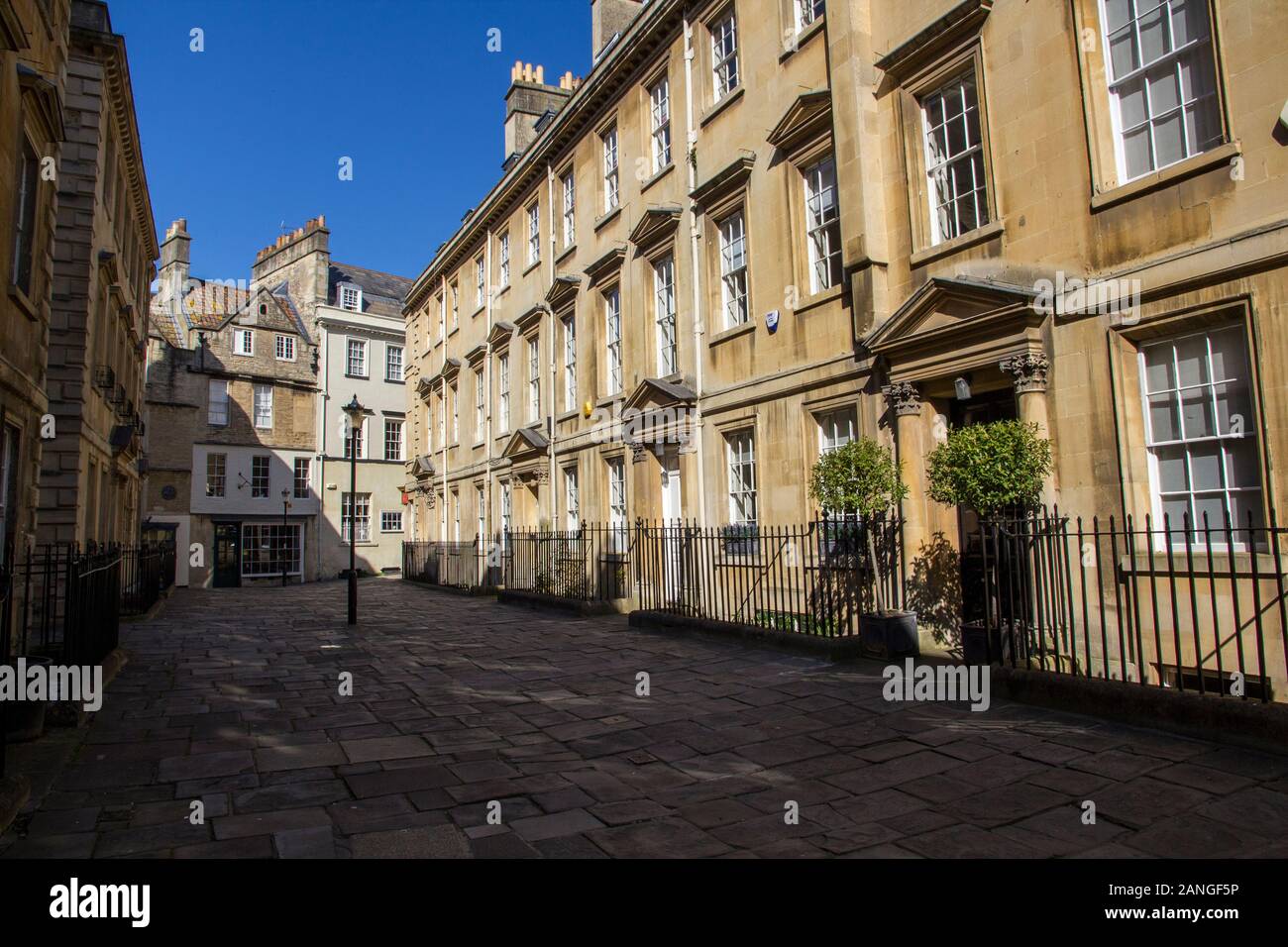 Badewanne, Großbritannien - 10 April, 2019. Lange Schatten auf die Gasse in den Innenhof werfen. Bath, England, UK, 10. April 2019 Stockfoto