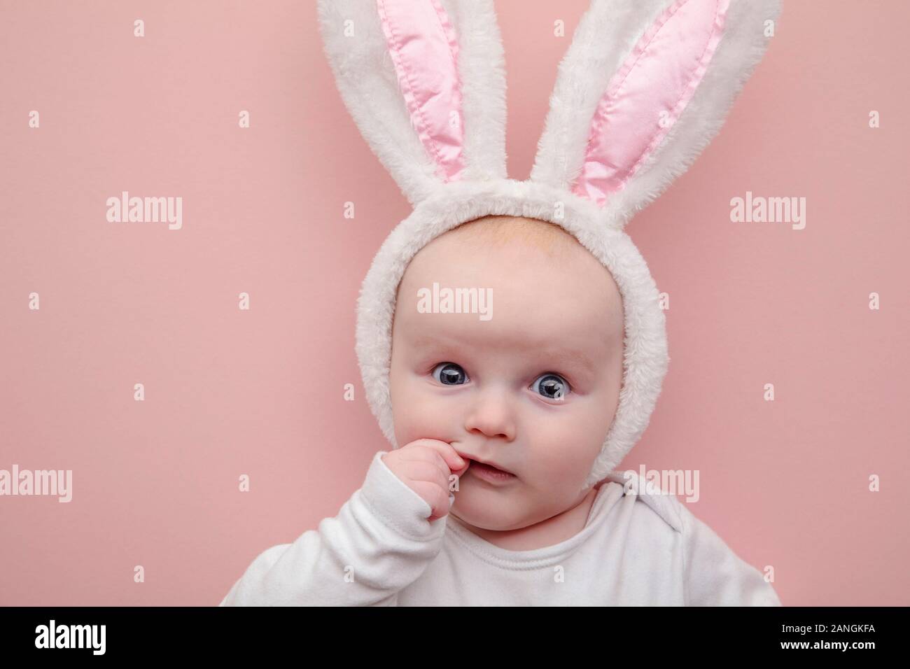 Süße kleine Baby tragen Osterhase hase Ohren auf einem rosa Hintergrund Stockfoto