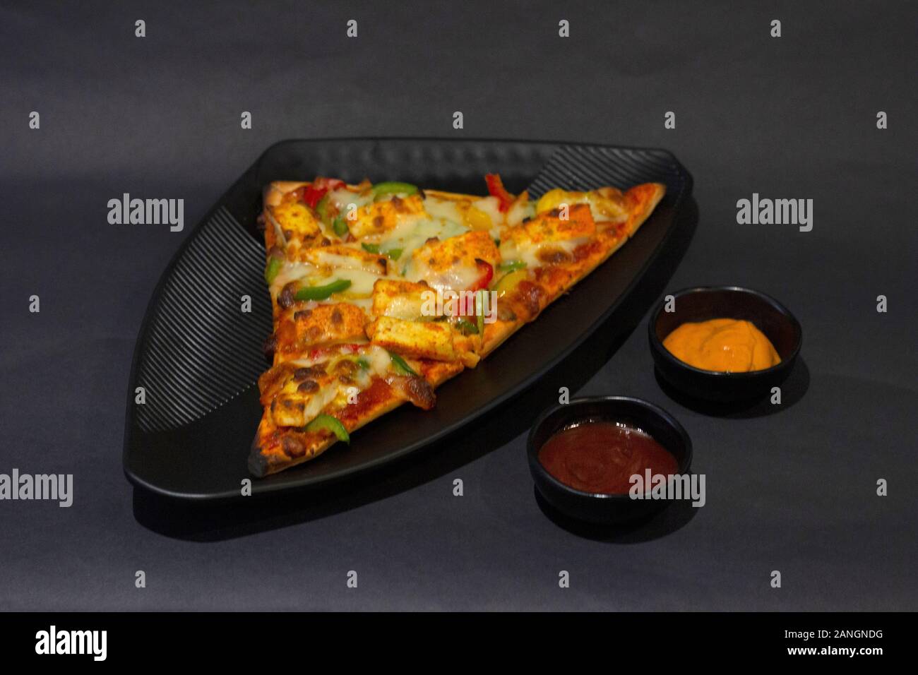 Paneer Pizza auf dunklem Hintergrund, Tischplatte close-up, Indien Stockfoto