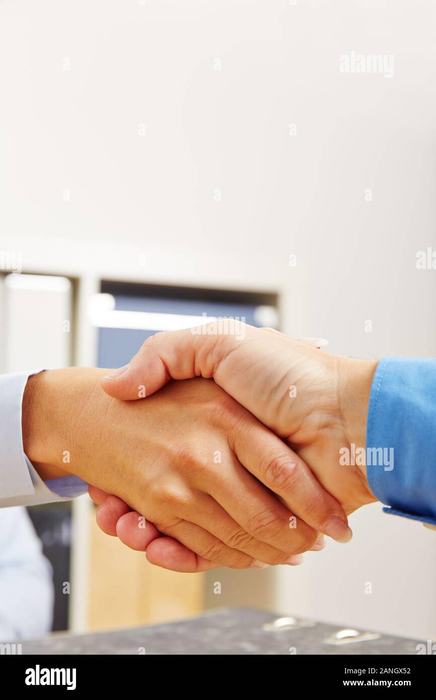 Handshake mit zwei Händen von Geschäftsleuten im Büro Stockfoto