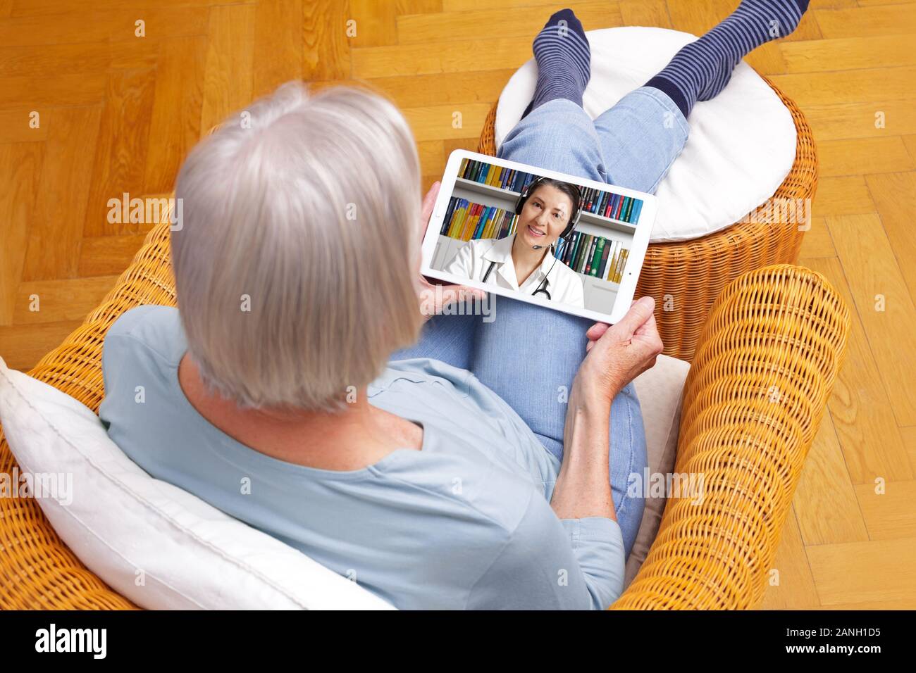 Telemedizin Konzept, alte Frau mit tablet pc während einer online Beratung mit Ihrem Arzt in Ihrem Wohnzimmer. Stockfoto