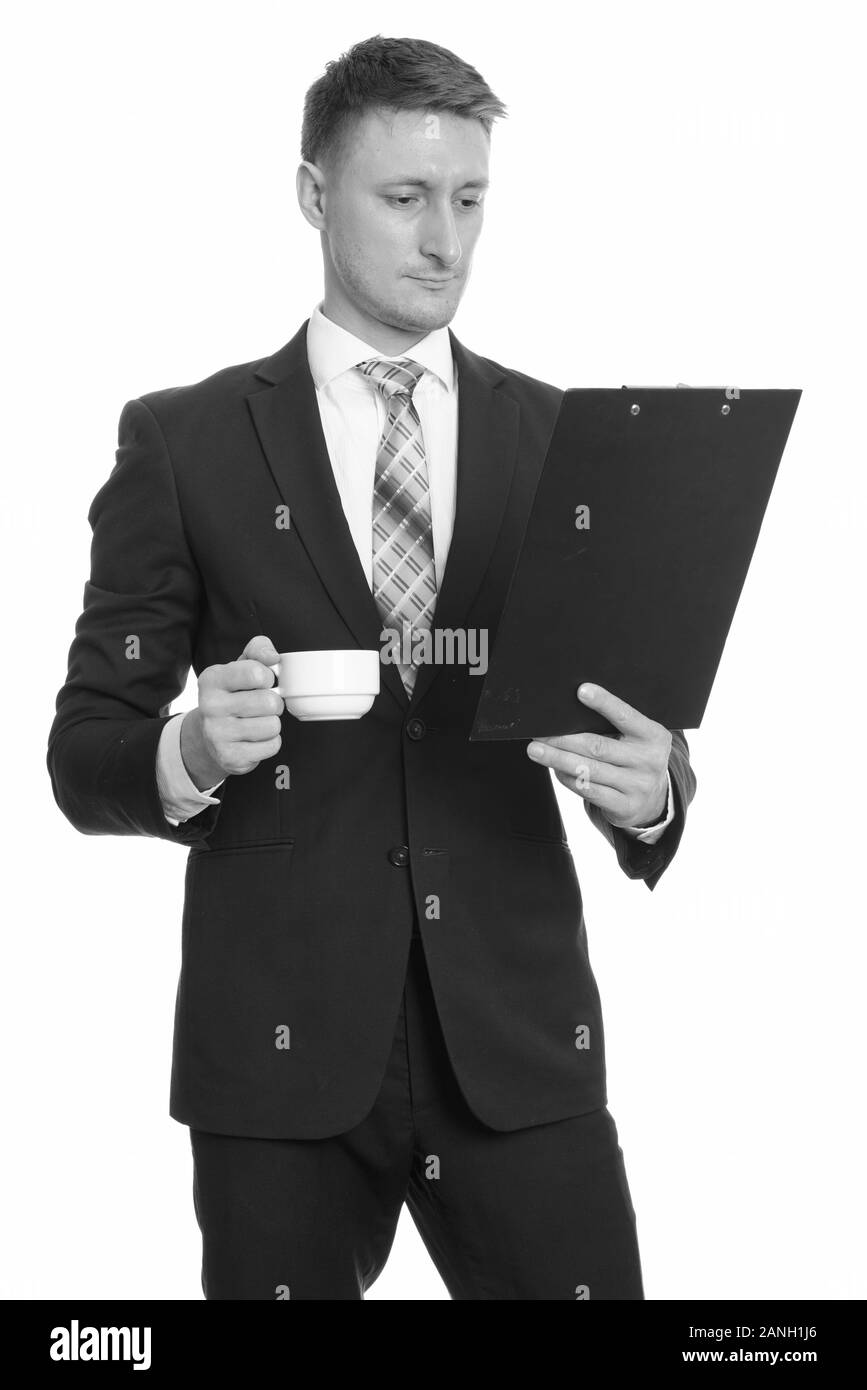 Stattlichen kaukasischen Geschäftsmann lesen Zwischenablage beim Trinken von Kaffee Stockfoto