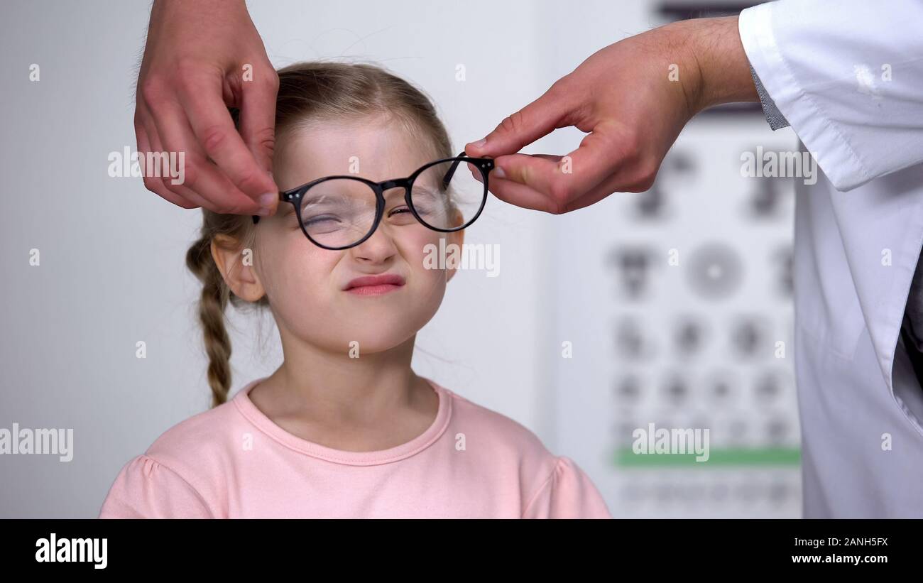 Optiker, korrigierende Brille auf Umgekippten Mädchen, Kindheit Augenkrankheiten Stockfoto
