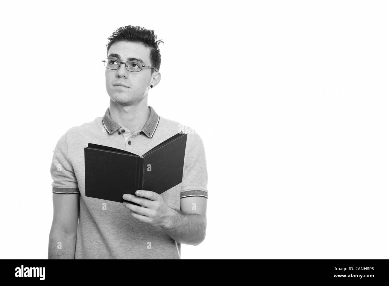 Studio shot junger Mann mit Buch beim Denken Stockfoto