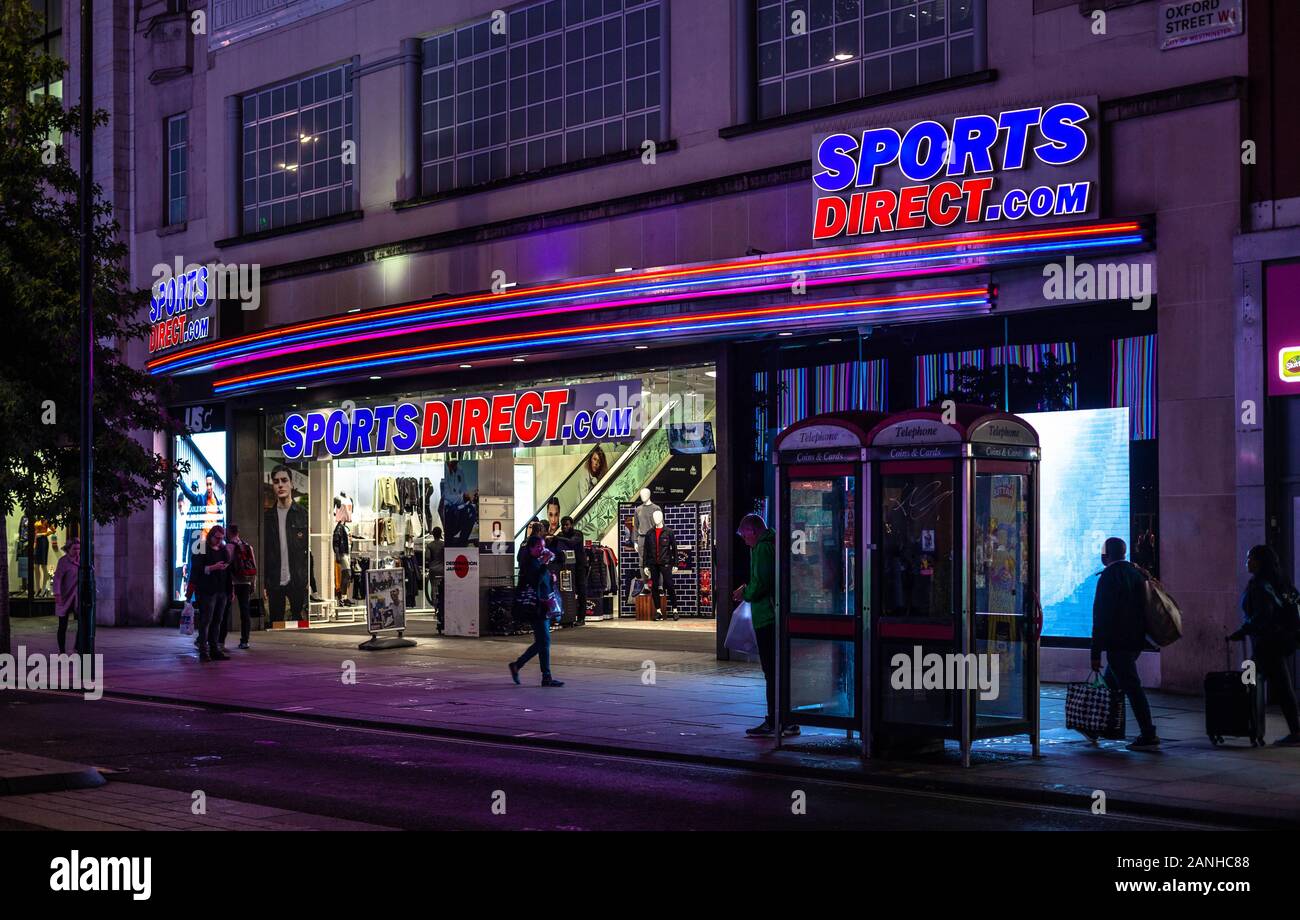 Helle und leuchtende Zeichen außerhalb eines Sport Direct.com Store auf der Oxford Street, London, England, UK. Stockfoto