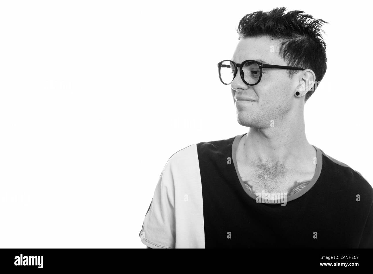Studio geschossen von geekelt, jungen Mann an der Seite suchen Stockfoto