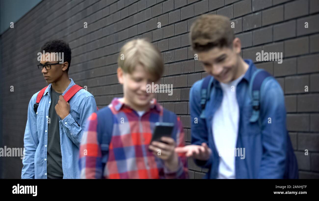 Schwarzen Studenten deprimiert über die Gefahren von Tyrannisierung über das Internet, Mitschüler Buchung offensive Video Stockfoto