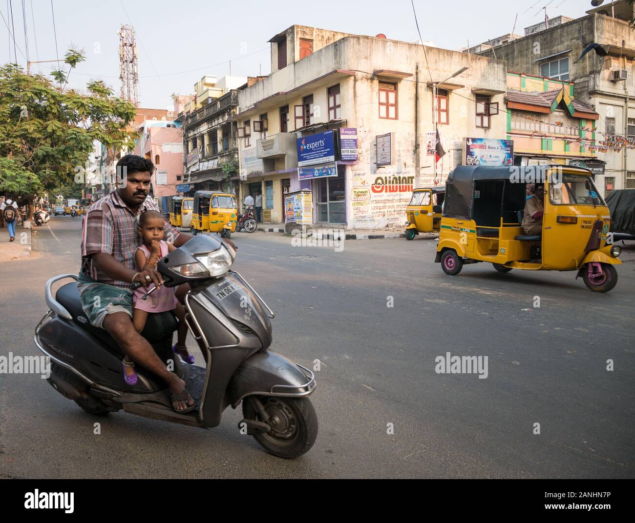 Gefährliches fahren. Eine indische Straße Szene mit einem Mann, der ein kleines Mädchen eine Fahrt auf dem Moped ohne Helm. Chennai, Tamil Nadu, Indien. Stockfoto