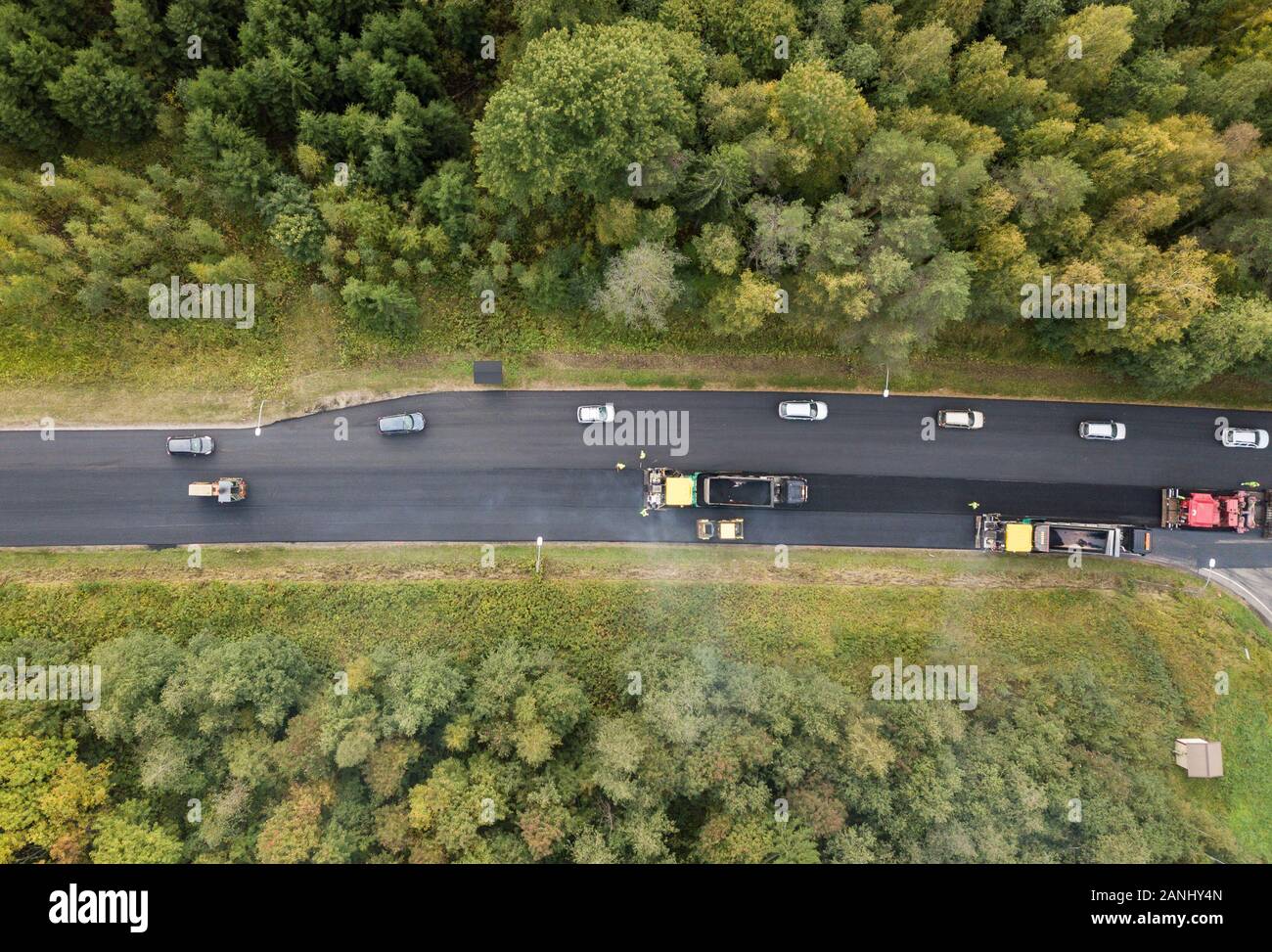 Schlange von Autos vorbei Asphalteinbau im Wald Autobahn Stockfoto