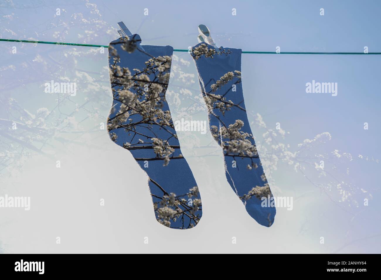 Doppelte Belichtung. Abstrakte Paar Socken hängen mit Heringe isoliert auf UK Wasch Wäscheleine. Frischekonzept. Stockfoto