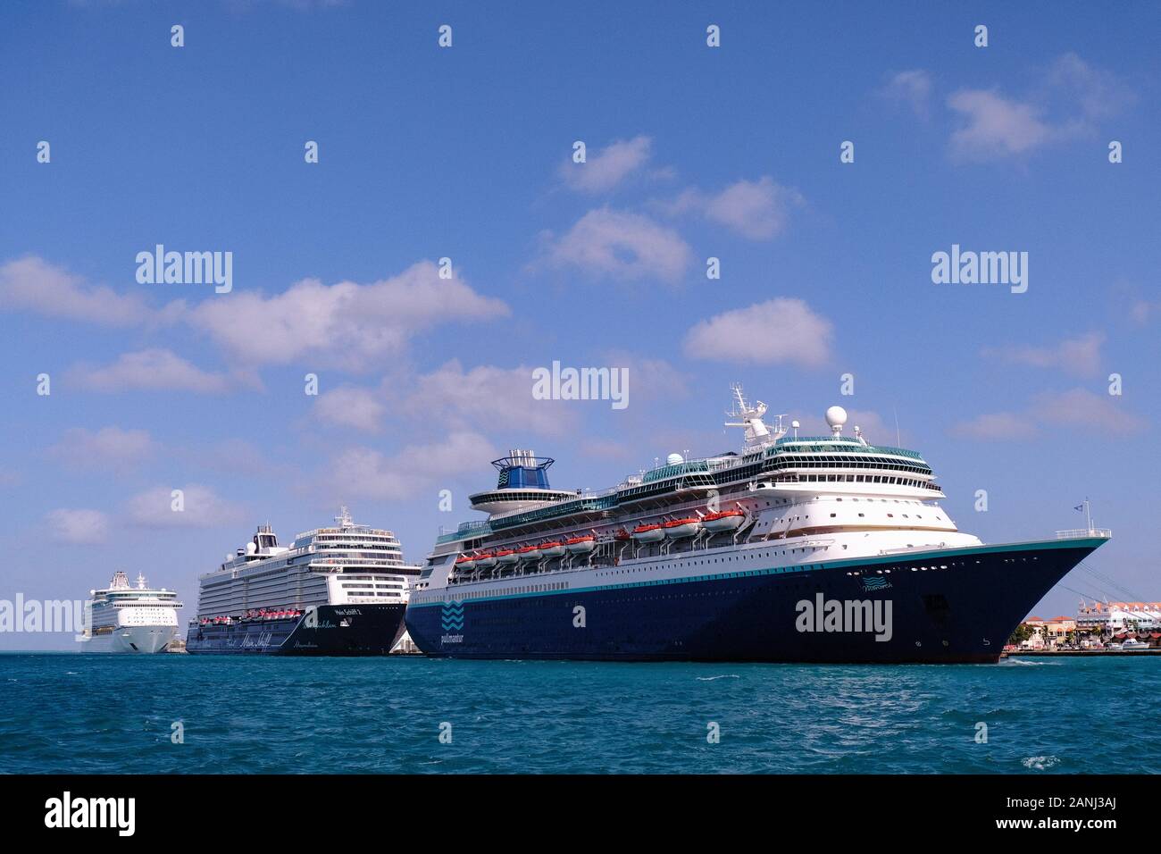 Eine Ansicht vom Meer von drei große Kreuzfahrtschiffe vertäut im Hafen von Aruba in die Niederländische Karibik für einen Tag besuchen Sie Mist eine Karibik Kreuzfahrt Stockfoto