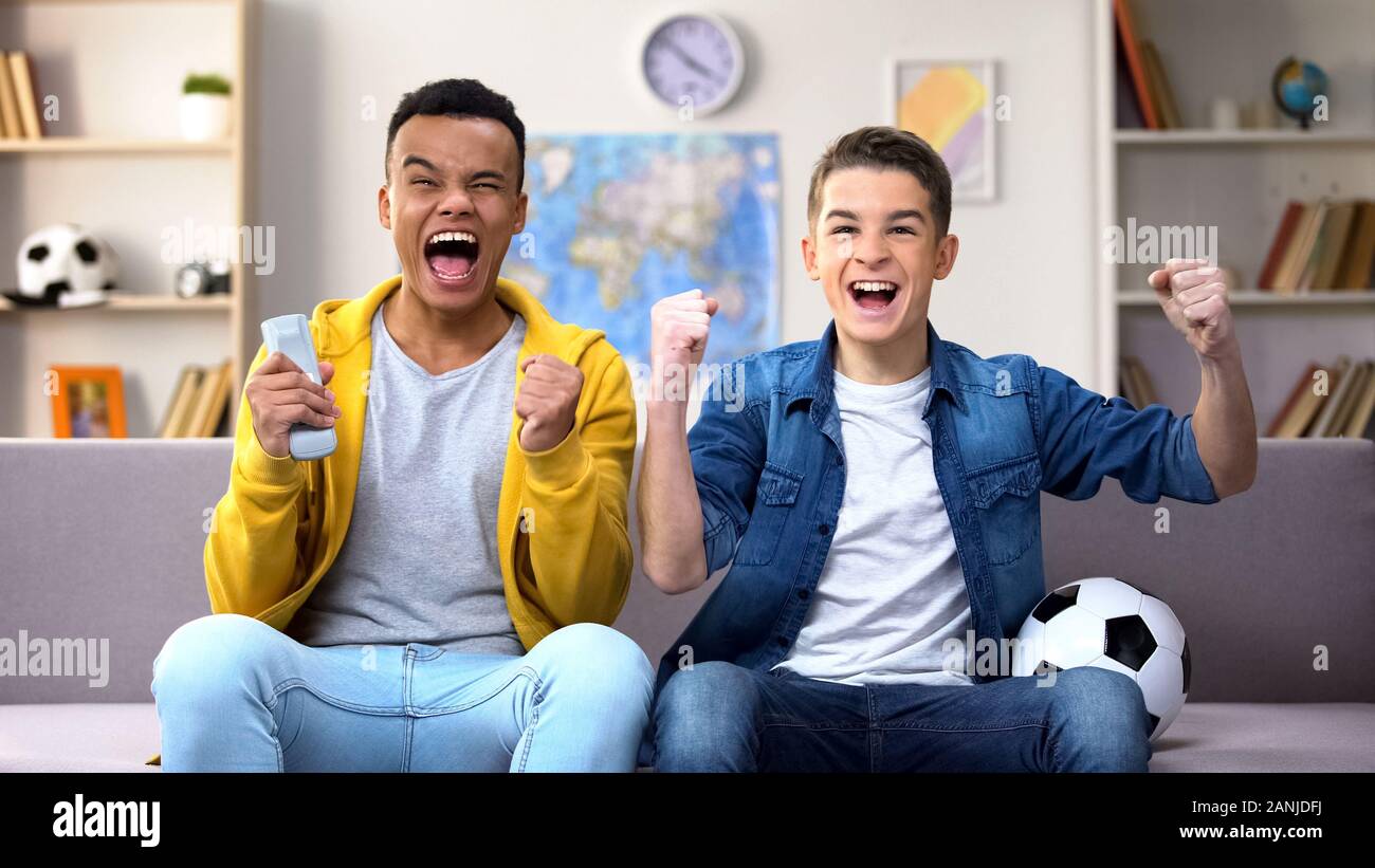 Multirassischen teen boys Jubel Fußball Mannschaft zum Sieg, Gleiches zu Hause Stockfoto