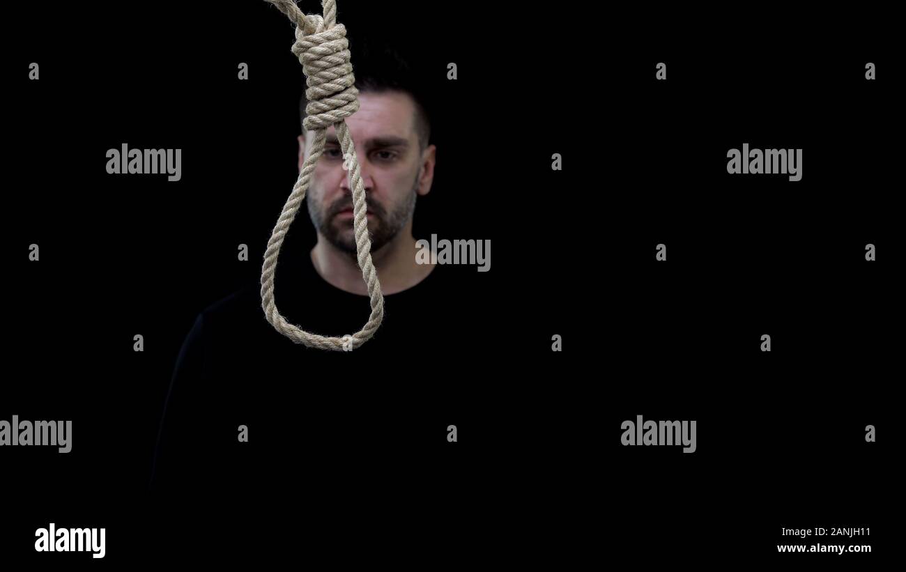 Verzweifelten Mann am Seil Loop auf schwarzem Hintergrund suchen, Selbstmord zu begehen, Stockfoto