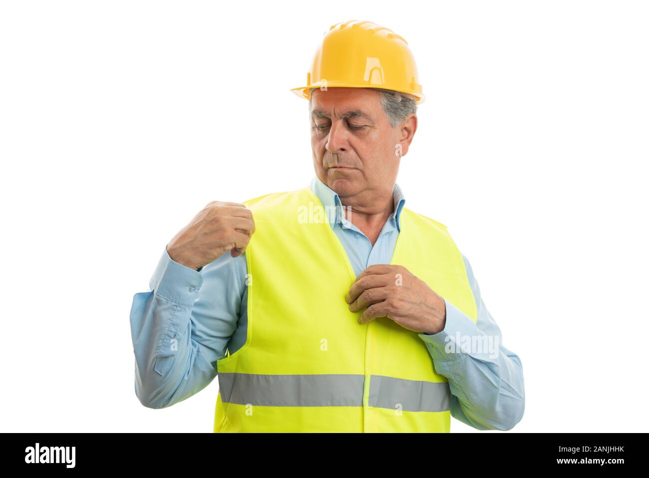 Alten männlichen builder Anordnen von fluoreszierenden Weste als Arbeit Kleidung fertig für die Arbeit an Weißen studio Hintergrund isoliert Stockfoto