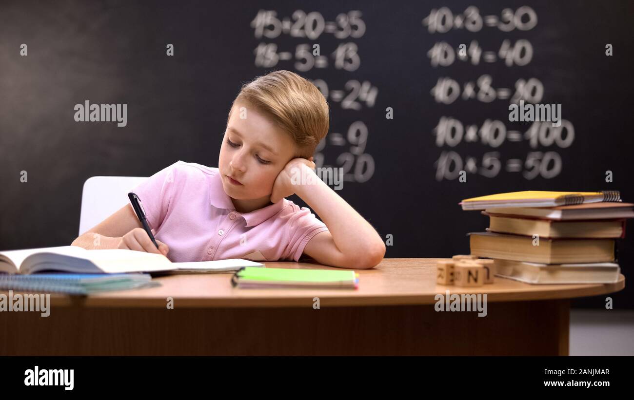 Gelangweilter Schüler am Schreibtisch sitzen, nicht bereit, Mathe Hausaufgaben zur Vorbereitung entspannt Stockfoto