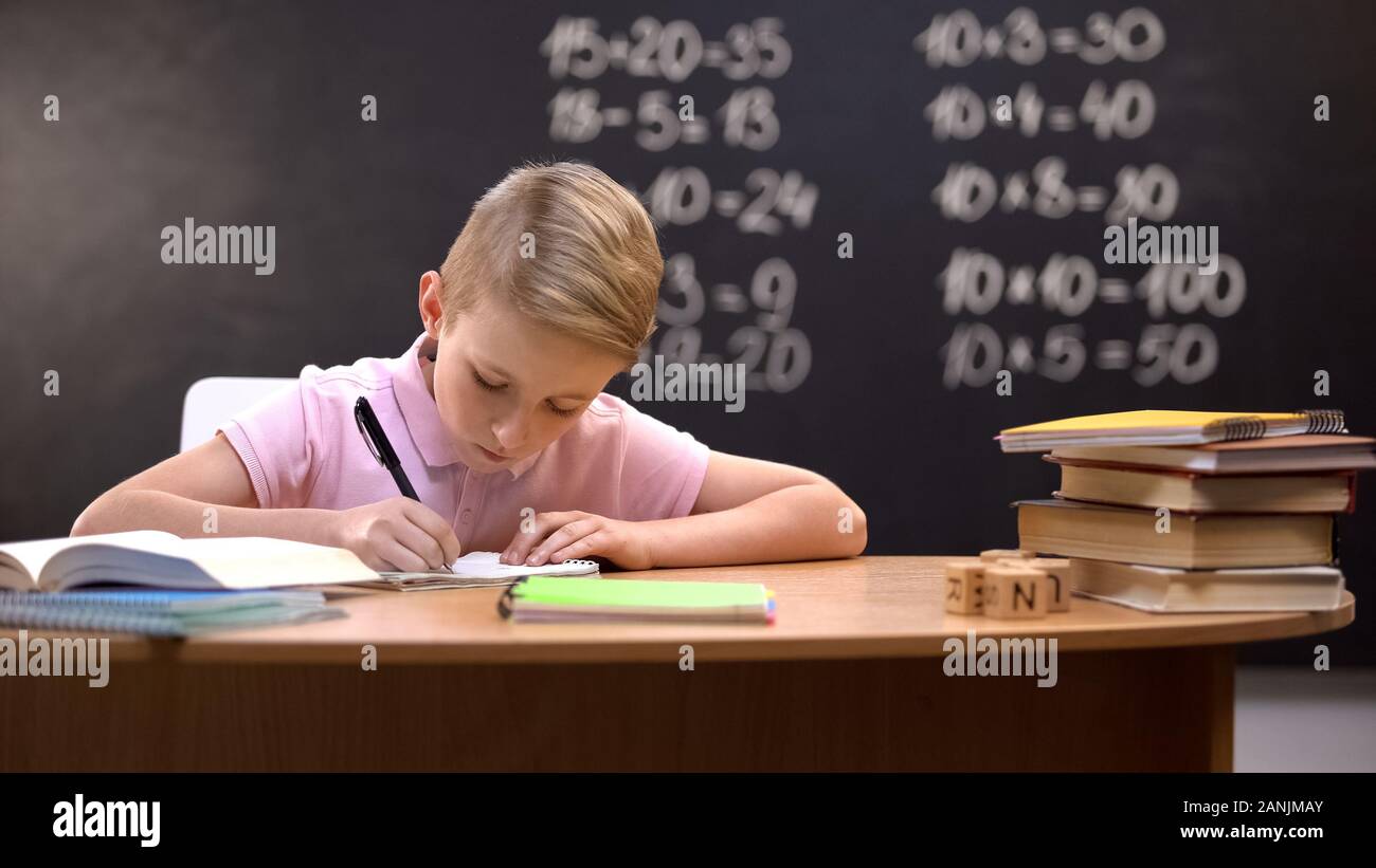 Fleißige Schüler seine Mathe Hausaufgaben, Lösen schwieriger Aufgaben aus dem Buch Stockfoto
