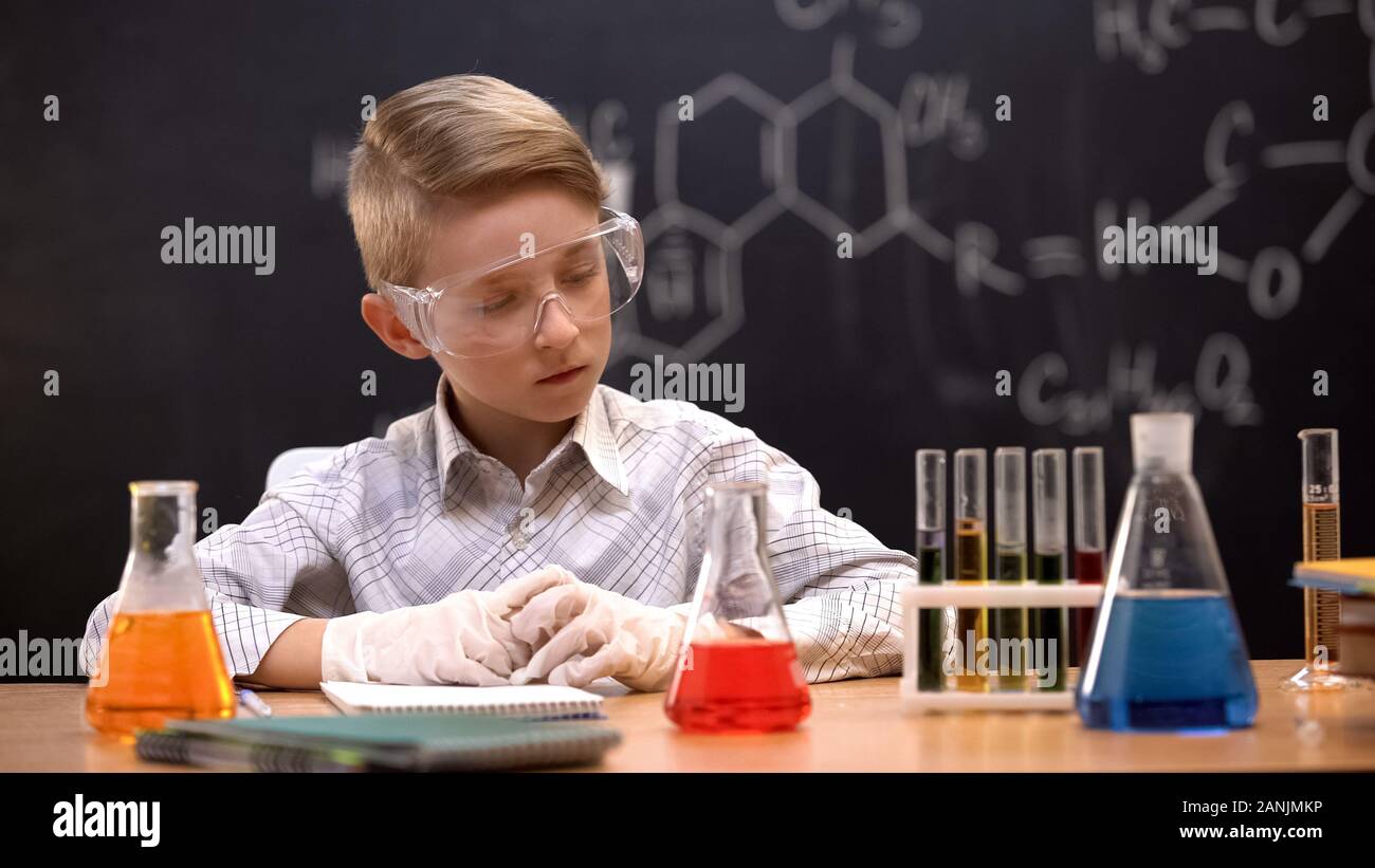 Schule Experimentator in Röhrchen mit Flüssigkeiten suchen, Analyse von Reaktionen Stockfoto