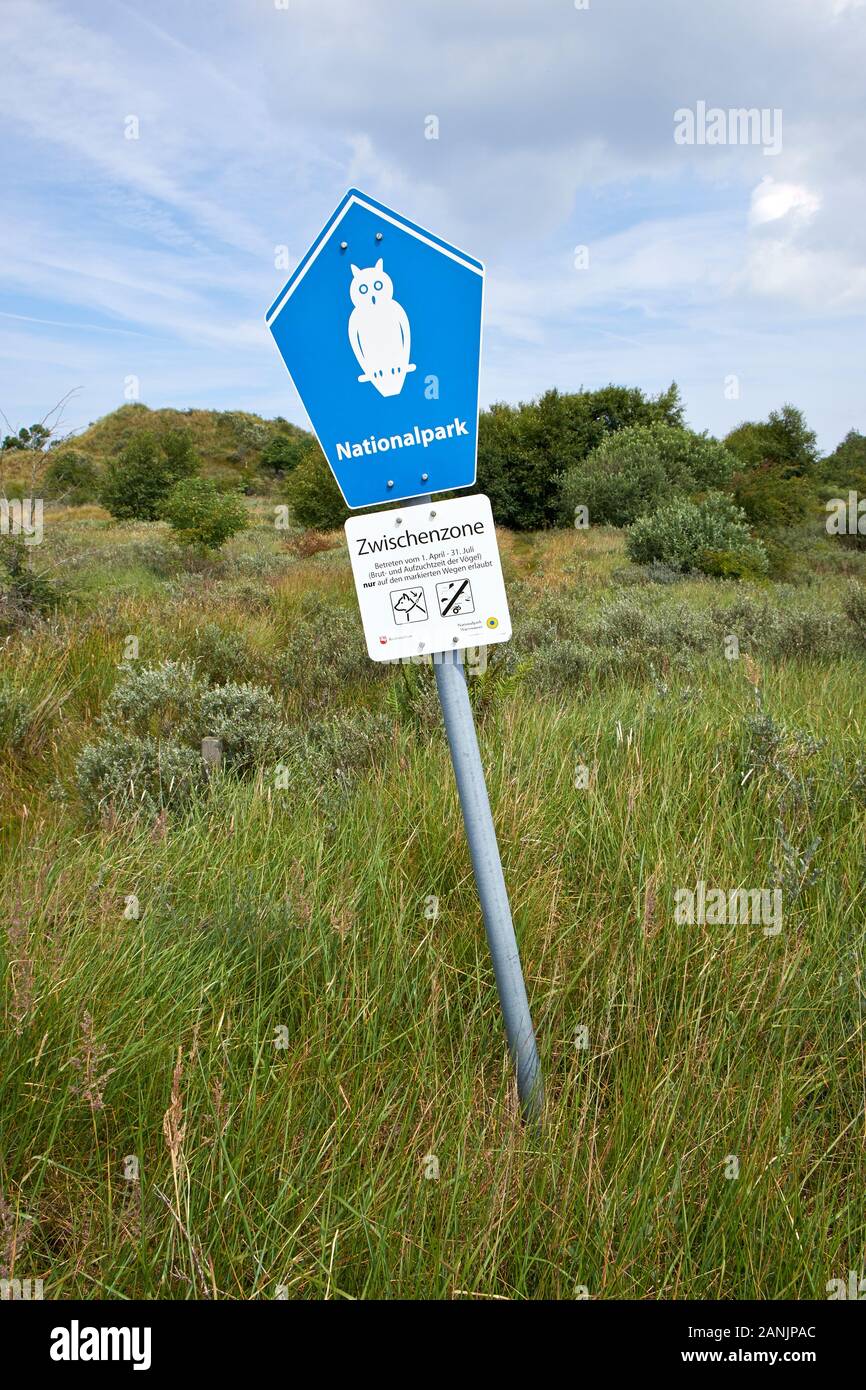 Gelehntes Metallschild mit einer bemalten weißen Eule, die auf ein Zwischengebiet im Nationalpark auf der Insel Borkum hinweist Stockfoto