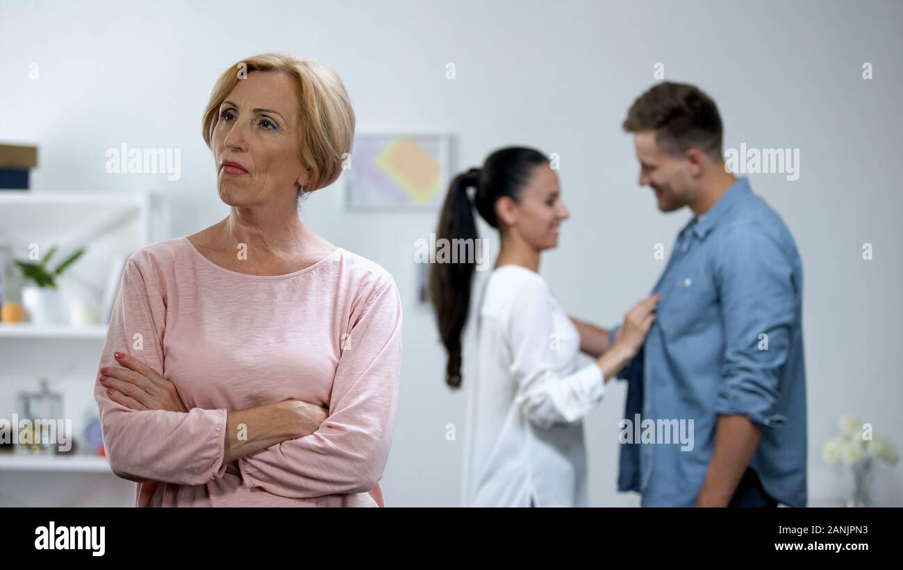 Wütende Mutter mit Hände gekreuzt, Paar in Liebe auf Hintergrund, Mangel an Aufmerksamkeit Stockfoto