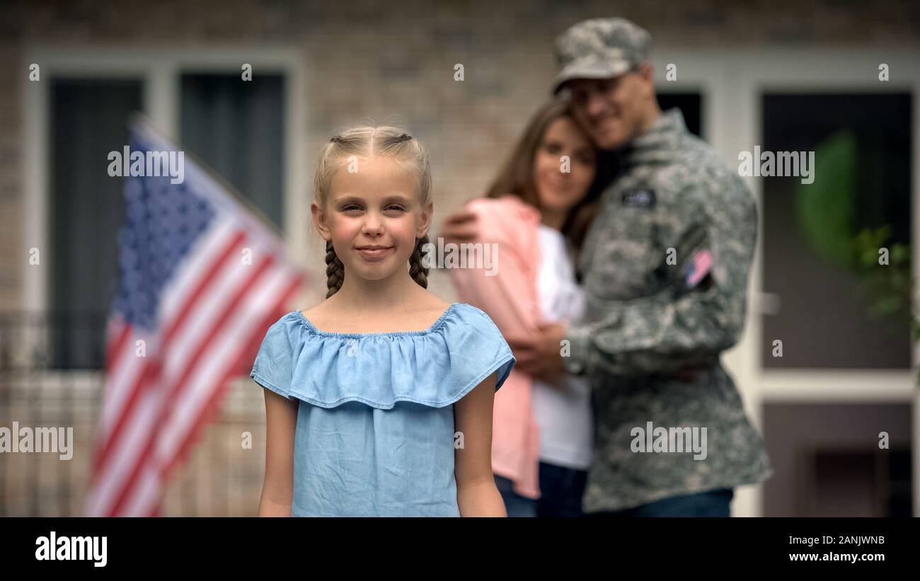 Kleines Mädchen lächelnd, amerikanische Fahne Streik vor Eltern, die Patrioten, die Familie Stockfoto