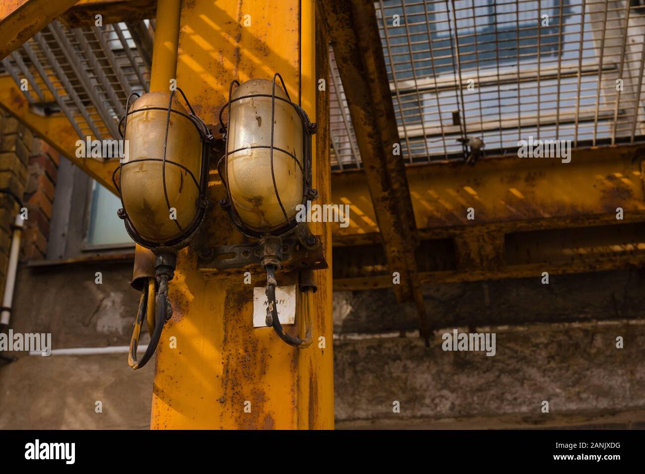 Zwei alte Stirnwand Lampen auf einem Stahlträger, Rusty Leuchten mit  Kühlergrill Schutz, Vintage, industriellen Look Lampe, Industrie, warmen  roten Schatten Stockfotografie - Alamy