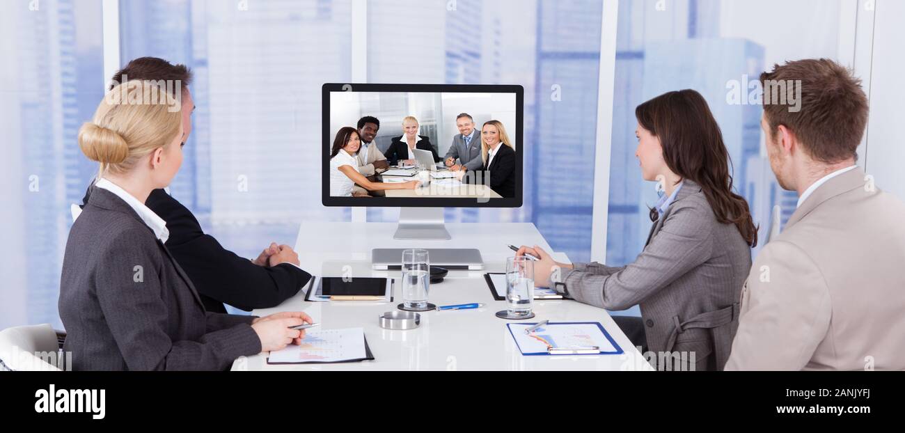 Geschäftsleute in Video Konferenz am Konferenztisch Stockfoto