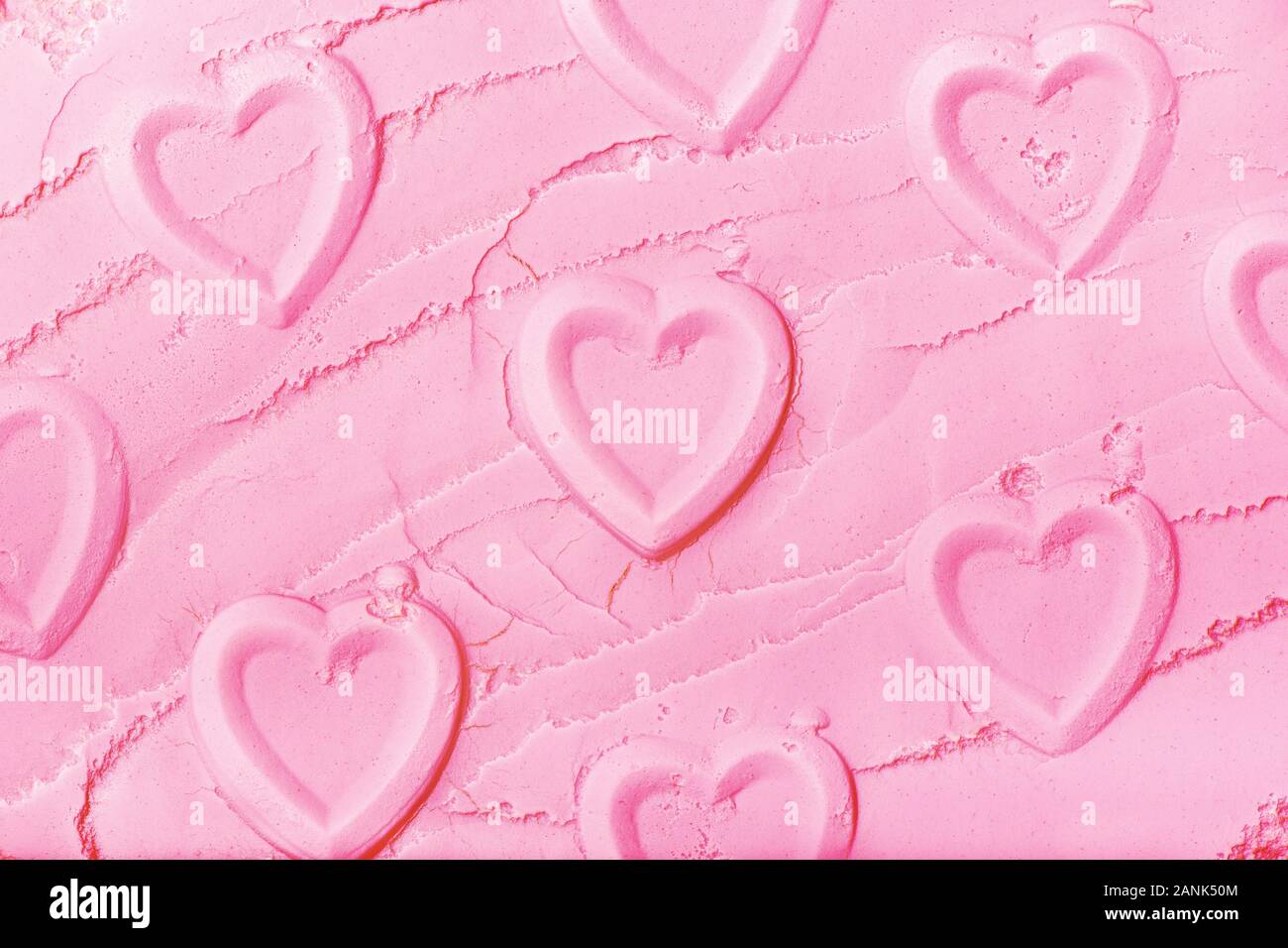 Nahaufnahme von Herzen auf rosa Pulver geprägt. Stockfoto