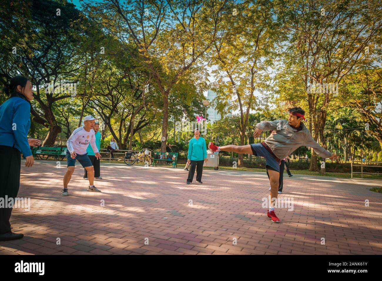 Bangkok/Thailand-06December2019: Lumphini Park Morning, eine Gruppe von Männern und Frauen, die das Freizeitspiel "Dschianzi" mit einem Mann spielen, der shuttlecock startet Stockfoto